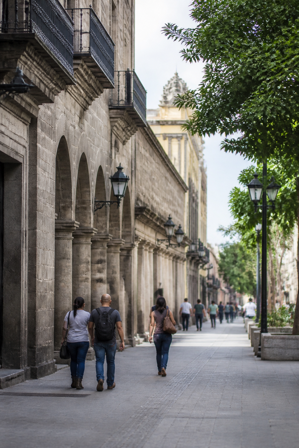 Calle del centro histórico de Guadalajara con edificios de cantera, arcos y gente caminando a media mañana